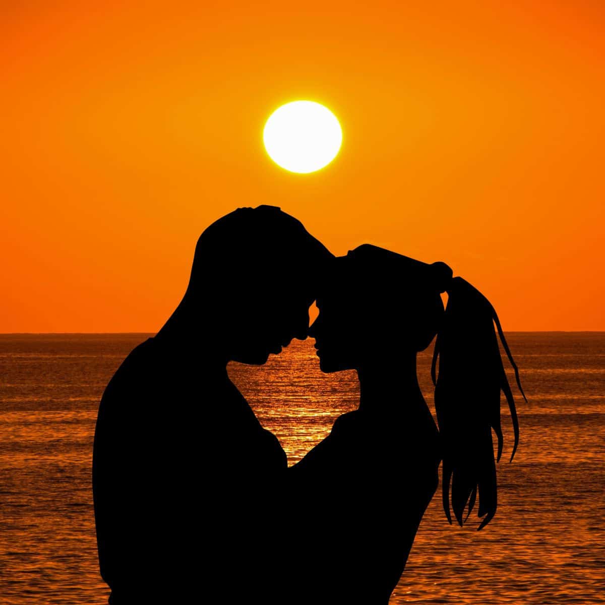 Couple with sun in the background.